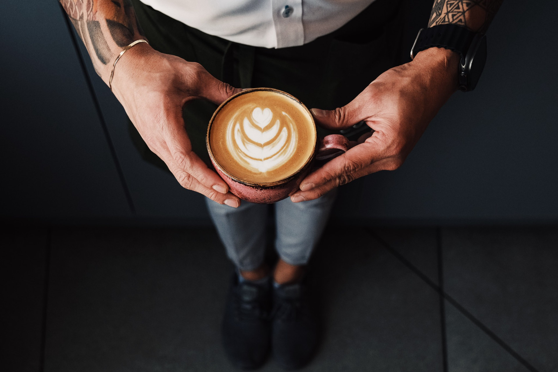 Hands holding latte with heart latte art